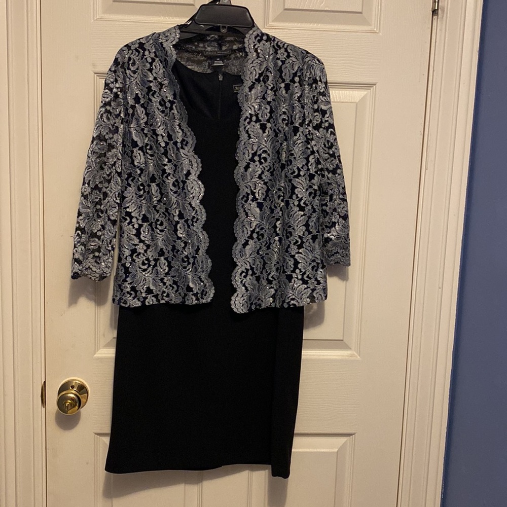 Black sleeveless round neck cocktail dress with lace black and silver jacket.